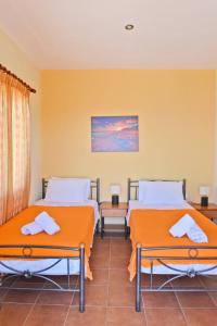 グロッサにあるVilla Malenaの黄色い壁の客室内のベッド2台