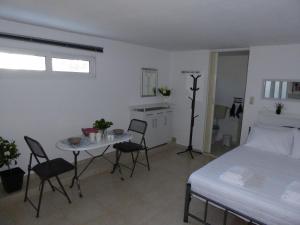 una camera con letto, tavolo e sedie di Elafonisi Vacation Green Studio ad Áyios Pandeleḯmon