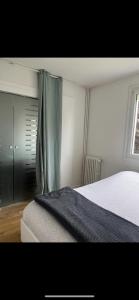 Schlafzimmer mit einem Bett und einem Fenster in der Unterkunft Beau T3 60m2 très cosy proche du centre ville in Saint-Jacques