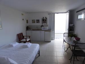 una camera con letto e tavolo e una cucina di Elafonisi Vacation Green Studio ad Áyios Pandeleḯmon