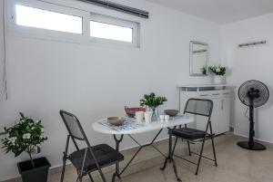 a white table and chairs in a white room at Elafonisi Vacation Green Studio in Agios Padeleimon +3 photos