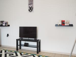 a living room with a tv on a white wall at Schöne Helle Wohnung in Mühlhausen