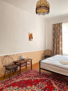 a bedroom with a bed and a table and a window at Unoyan Guest House in Gyumri