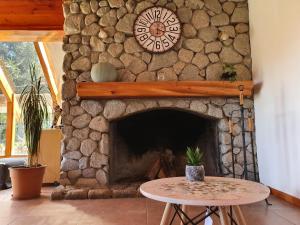 a stone fireplace with a clock on a wall at Encanto del Rio in Villa La Angostura