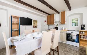 una sala da pranzo bianca con tavolo e sedie bianchi di 3 Bedroom Lovely Home In Nerezine a Nerezine (Neresine)