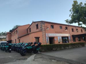 una fila de motocicletas estacionadas frente a un edificio en El Huésped del Sevillano AR, en Lagartera