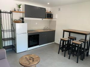 cocina con nevera blanca y mesa en Charmant logement avec un extérieur et un jacuzzi en Lançon-Provence