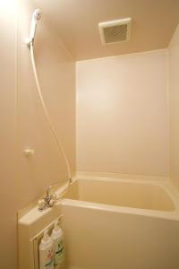 a bathroom with a bath tub with a shower at FUTO HOUSE -Ippon no Enpitsu- in Ito