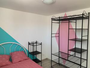a bedroom with pink and black shelving at Charmant logement avec un extérieur et un jacuzzi in Lançon-Provence
