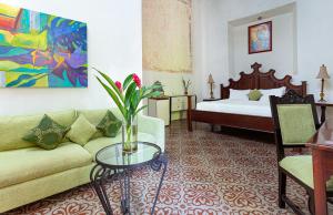a living room with a couch and a bed at VILLA MERIDA BOUTIQUE HOTEL - Adults Only in Mérida