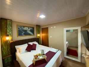 a bedroom with a bed with a tray of fruit on it at Queiroz Palace Hotel in Siqueira Campos