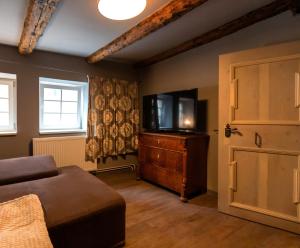 a living room with a tv on a dresser and a door at Blauer Stieg in Quedlinburg