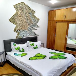 ein Schlafzimmer mit einem Bett mit grünen Blättern darauf in der Unterkunft Apartament Camelia in Petroşani