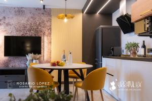 een keuken en eetkamer met een tafel en stoelen bij Urbanlux Olimpia Sleep & Park in Albacete