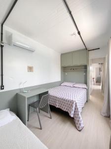 a bedroom with a bed and a desk and a table at Container com clima de montanha! in Siderópolis