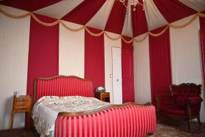 um quarto com paredes com riscas vermelhas e brancas e uma cama em Chateau Morinerie 
