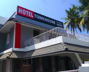 a hotel tower with a sign on top of it at Hotel Sunday - Townhouse Club Airport Trivandrum in Trivandrum