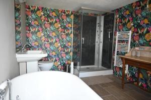 uma casa de banho com um chuveiro, um WC e um lavatório. em Chateau Morinerie 