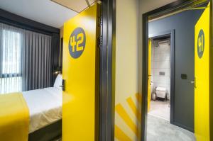 um quarto de hotel com uma porta amarela e uma cama em Trip Park Hotel em Istambul