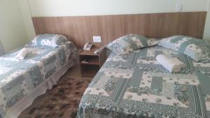 เตียงในห้องที่ Caçula Palace Hotel
