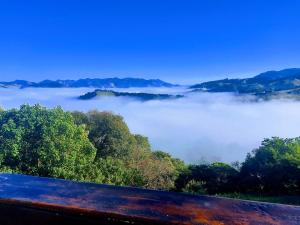 a view of a fog covered valley with trees at Tocas do Lago in São Bento do Sapucaí