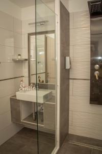a bathroom with a sink and a shower at Oros House Apartmanház in Orosháza