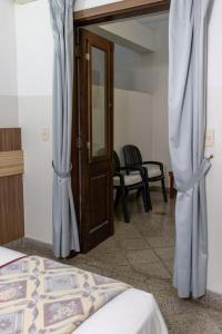 Habitación con cama y puerta con cortinas en Das Heim Hotel, en Asunción