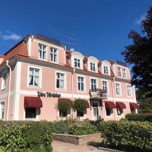 a large pink building with a balcony at Ydre BnB in Österbymo