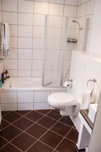 een badkamer met een toilet, een bad en een wastafel bij Schöne Ferienwohnung in der Welterbe Region in Trechtingshausen
