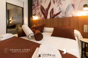 a large bed with brown pillows on top of it at Urbanlux Olimpia Superior in Albacete