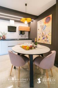 a dining room with a table with chairs and a painting at Urbanlux Olimpia Superior in Albacete