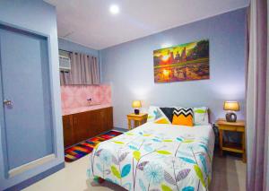 um pequeno quarto com uma cama e um quadro na parede em Lovely Studio 1 Bedroom Apartment, Olongapo City Centre em Olongapo