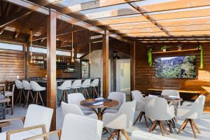 a restaurant with white chairs and tables and a bar at Pousada Serra Verde in Cambará