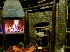a stone fireplace with a chair in front of it at Horizon Green Guest House in Randfontein