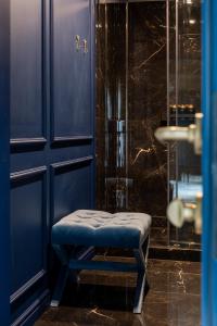 a blue bathroom with a stool in front of a shower at Poderey Villas in Yaremche