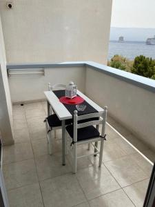 una mesa y una silla en un balcón con vistas al océano en Apartamentos playa chica / playa las gaviotas, en Santa Cruz de Tenerife