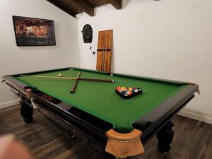 a green pool table with balls in a room at סוויטות נוף לתבור in Giv'at Avni