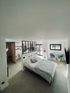 a white bedroom with a bed and a table and chairs at La suite provençale in Marseille