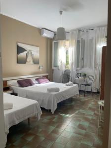 a bedroom with two beds and a table and chairs at Hotel Cappello in Cesena