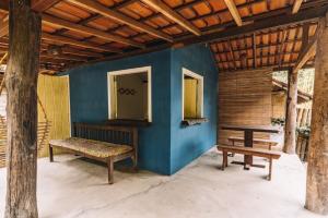 凱拉伊夫的住宿－Vila das Ondas Caraíva，蓝墙房间里一张长凳和一张桌子