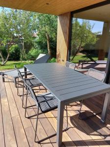 a gray picnic table and chairs on a deck at Geniet van alle comfort tussen Ieper en Heuvelland in Ieper