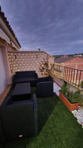 een patio met zwart meubilair op een balkon bij La Picossa in Valderrobres