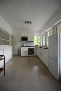 eine große Küche mit weißen Schränken und einem Kühlschrank in der Unterkunft Le Paradis Mosan in Waulsort