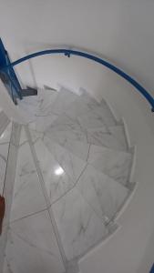 a white marble floor with a blue hose at Village Galés Maragogi - Chalé 03 in Maragogi