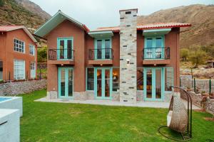 a house with a mountain in the background at Auka Boutique in Urubamba