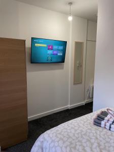 ブラッドフォードにあるBv Comfy Budget Studio At Quebec Street Bradfordのベッドルーム1室(壁に薄型テレビ付)