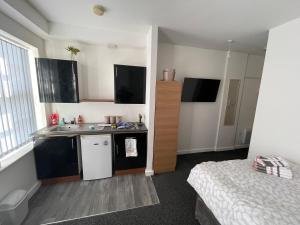 una piccola cucina con lavandino e un letto in una camera di Bv Comfy Budget Studio At Quebec Street Bradford a Bradford