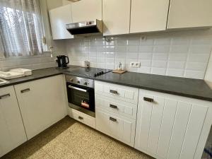 La cuisine est équipée de placards blancs et d'un four avec plaques de cuisson. dans l'établissement Superbe appartement DUPLEX avec Jacuzzi, à Bruxelles