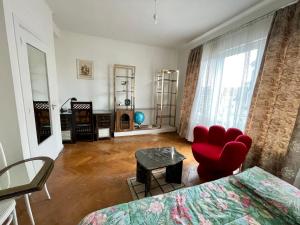 a living room with a bed and a red chair at Superbe appartement DUPLEX avec Jacuzzi in Brussels