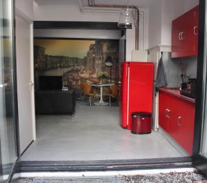 a red refrigerator in a kitchen with a table at Achterhuis Slapen en Eten in Gouda